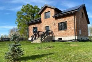 a brick house with a staircase in a yard at Dom na Włościach in Ostrykół Włościański