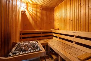un sauna en bois avec une grande baignoire contenant des bûches dans l'établissement Fortuna Eco - Boutique Hotel, à Băile Tuşnad