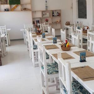 a dining room with white tables and white chairs at Varadero Zanzibar Hotel in Kendwa