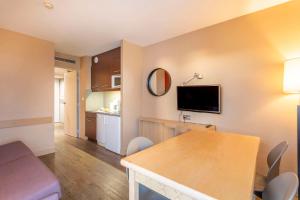 a room with a kitchen and a living room at Comfort Aparthotel Marseille Prado in Marseille