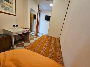 sypialnia z łóżkiem, biurkiem i umywalką w obiekcie Hotel Fiorella w mieście Senigallia