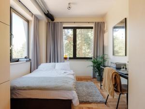 a bedroom with a bed and a desk and windows at Stereo House by Larsen in Tallinn