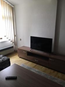 uma sala de estar com uma televisão de ecrã plano num suporte em Little Vlasina em Surdulica