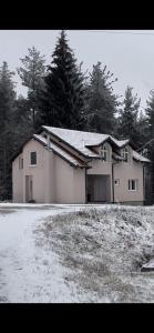 a house with snow on the ground in front of it at Little Vlasina in Surdulica
