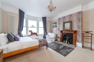 a bedroom with a bed and a fireplace at Comfy 3BR grd floor flat wprivate garden, NE in London