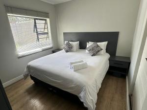a bedroom with a large white bed with a window at Conti-INN Guesthouse in Queenstown