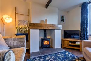 uma sala de estar com lareira e televisão em Finest Retreats - Spring Cottage em Endon