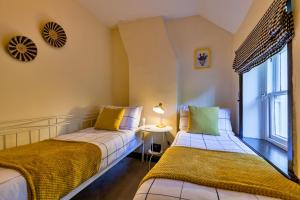 dwa łóżka w pokoju z oknem w obiekcie Finest Retreats - Spring Cottage w mieście Endon