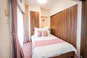 a bedroom with a large bed with a wooden headboard at はなハウス 3F in Ginowan
