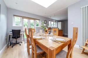 a dining room with a wooden table and chairs at Comfy 3BR grd floor flat wprivate garden, NE in London