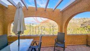 a patio with a table and chairs and an umbrella at Bungalow Alma Live It Costablanca in Benitachell