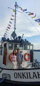 a man and woman standing on the front of a boat at Saimaa Experience in Savonlinna