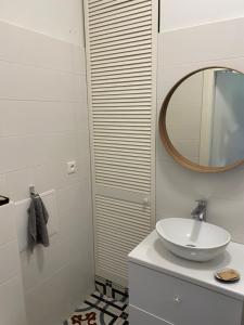 a white bathroom with a sink and a mirror at Apartament III Aleja NMP in Częstochowa +8 photos