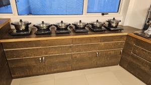 eine Reihe von Schüsseln auf einer Theke in einer Küche in der Unterkunft INDIANA HILLS in Shillong