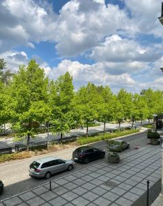 two cars parked in a parking lot with trees at Apartament III Aleja NMP in Częstochowa