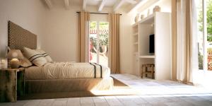 a bedroom with a bed and a sliding glass door at Hotel Rural Sant Ignasi in Ciutadella
