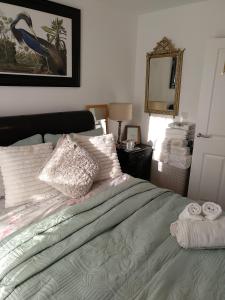 1 dormitorio con cama con almohadas y espejo en House Rose 1 en Prescot