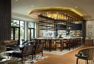 a restaurant with a bar with a large chandelier at Hotel Centro Sonoma Wine Country, Tapestry Collection Hilton in Rohnert Park