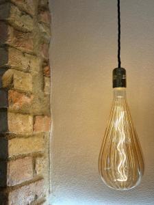 a glass light bulb hanging from a brick wall at Podere Bellavista in San Gimignano