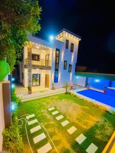 une maison avec une cour et une piscine la nuit dans l'établissement فيلا مفروشة بالكامل, à Naj‘ al Aḩwāl