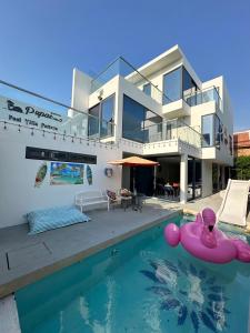 a house with a swimming pool in front of it at Pupae Pool Villa Pattaya in Pattaya South