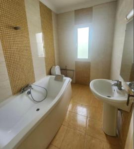 a bathroom with a large tub and a sink at Villa à yasmine hammamet in Nabeul