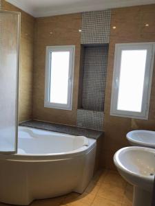 a bathroom with a tub and a toilet and a sink at Villa à yasmine hammamet in Nabeul
