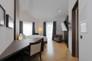 a bedroom with a bed and a desk and a television at DEVIN Art Hotel in Düsseldorf