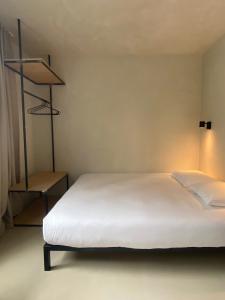 a bedroom with a white bed and a shelf at Edville Studio in Ghent
