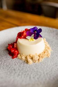 a small white cake with flowers on top on a plate at Sweeney Hall Hotel in Oswestry +14 photos