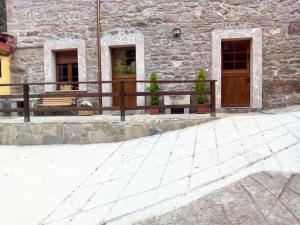 La RieraにあるStudio with terrace and wifi at La Rieraの石造りの建物前の木製のベンチ