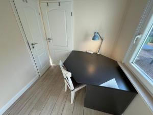 een kleine kamer met een zwart bureau en een stoel bij Haus-Selkie in Timmendorfer Strand