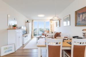 eine Küche und ein Esszimmer mit Tisch und Stühlen in der Unterkunft Ferienwohnung Ferhaaling mit direktem Seeblick in Nordstrand
