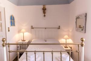 a bedroom with a bed with two lamps on both sides at Beautiful Oia Villa - Spectacular Sea Views - Sunset & Caldera Views - Aegean Serenity Villa in Oia