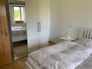 a bedroom with a white cabinet and a bed at Ferienwohnung Christensen in Murnau am Staffelsee