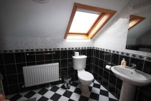 een badkamer met een toilet, een wastafel en een raam bij Pooreen House in Inverin