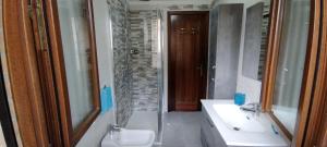 ein Bad mit 2 Waschbecken, einer Dusche und einem Spiegel in der Unterkunft Apartment Maria & Patrizio in Lignano Sabbiadoro