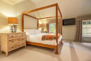 a bedroom with a large canopy bed with a mirror at The Gate House D in Docking