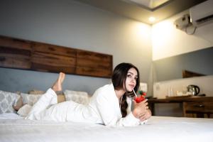 a woman laying on a bed holding a flower at The Bay Agonda in Agonda