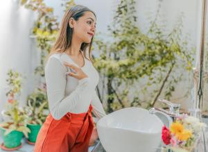 a woman standing in front of a bathroom sink at The Bay Agonda in Agonda