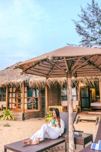 a woman sitting on a bench in front of a building at The Bay Agonda in Agonda