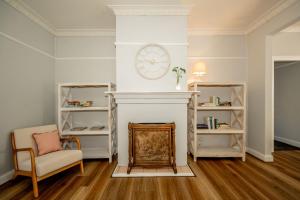 a living room with a fireplace and a clock on the wall at Piper Belle in Tamworth