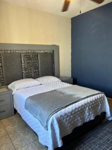- une chambre avec un grand lit et un mur bleu dans l'établissement Recámara cedro, à Saltillo