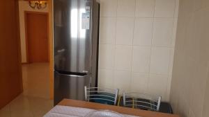 einen Kühlschrank aus Edelstahl in einer Küche mit Stühlen in der Unterkunft Remarkable 3-Bed House in Machico in Machico