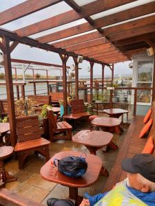 an outdoor patio with wooden tables and benches at Hooper's Sandy Beach Guest Rooms in Swansea
