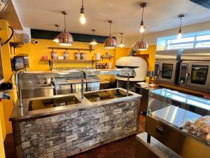 uma cozinha com electrodomésticos de aço inoxidável num restaurante em Hoopers Sandy Beach Guest Rooms em Swansea
