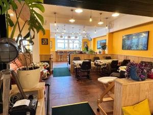 ein Restaurant mit Tischen und Stühlen und gelben Wänden in der Unterkunft Hoopers Sandy Beach Guest Rooms in Swansea