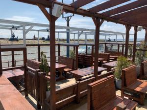 a restaurant with wooden benches and tables on the beach at Hooper's Sandy Beach Guest Rooms in Swansea