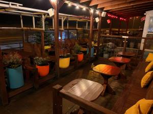 a restaurant with benches and tables and potted plants at Hooper's Sandy Beach Guest Rooms in Swansea