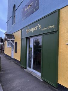 ein Geschäft vor einem Café mit offener Tür in der Unterkunft Hoopers Sandy Beach Guest Rooms in Swansea